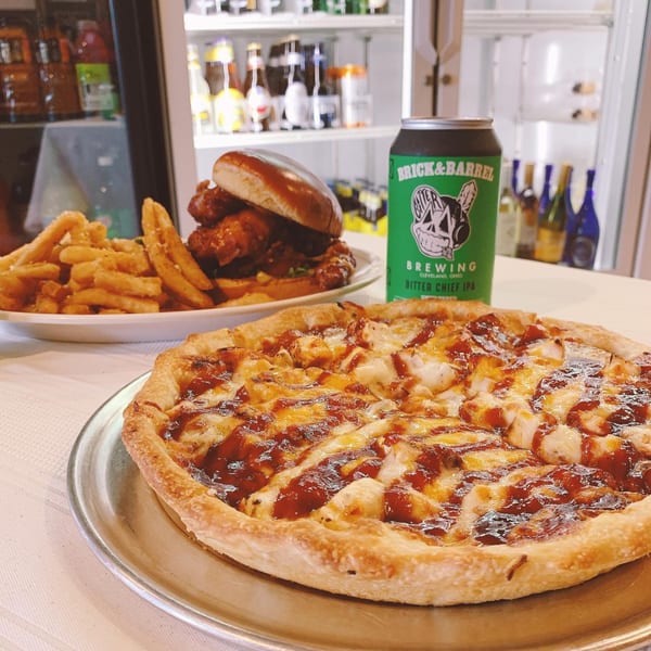 Sainato's deep-dish pizza, a chicken sandwich with fries, and a can of Brick & Barrel beer.